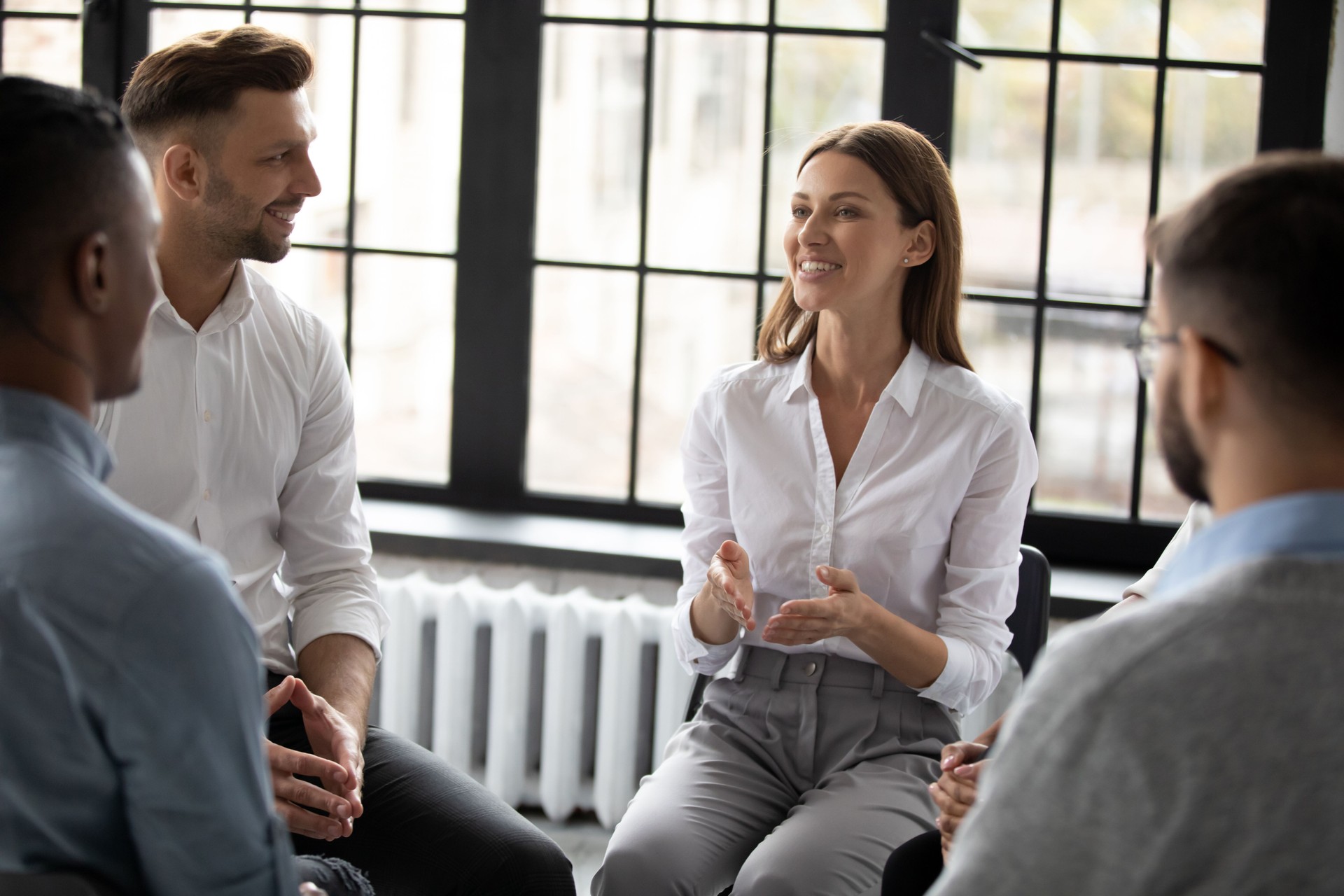 Confident smiling woman psychologist coach speaking at meeting